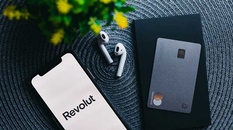 Smartphone mit Revolut-App und Debitkarte
