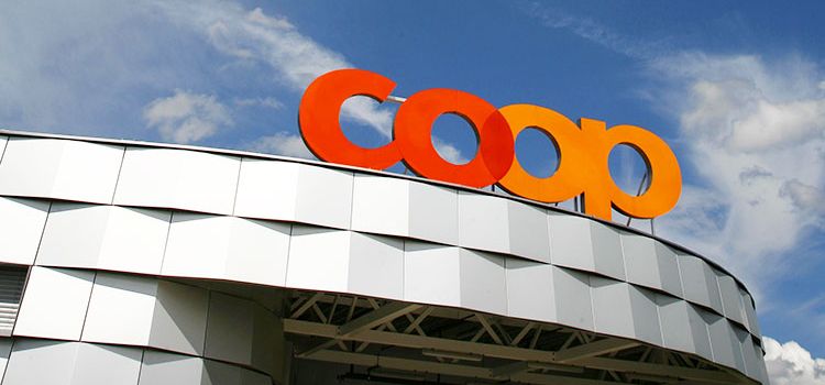 Coop-Logo auf Dach vor blauem Himmel