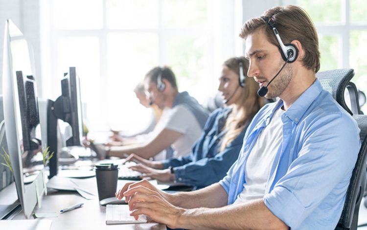 Mitarbeiterinnen und Mitarbeiter eines Callcenters der Arbeit