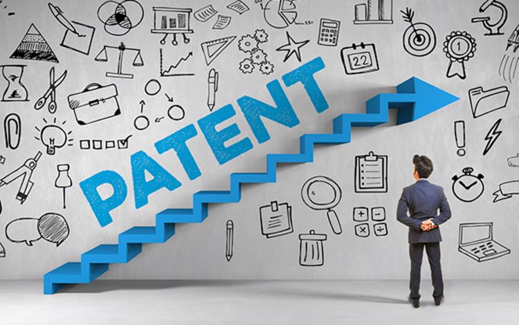 Manager im Anzug vor einer Wand mit der Aufschrift: Patent