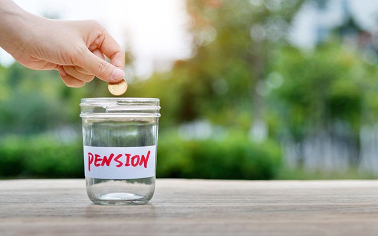 Glas mit Aufschrift "Pesnion" und eine Hand, die eine Münze in das Glas wirft