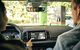 Eine Dame bedient in ihrem Auto über den Monitor das In-Car-Payment