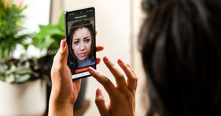 Eine junge Frau registriert sich am Smartphone zum biometrischen Bezahlen