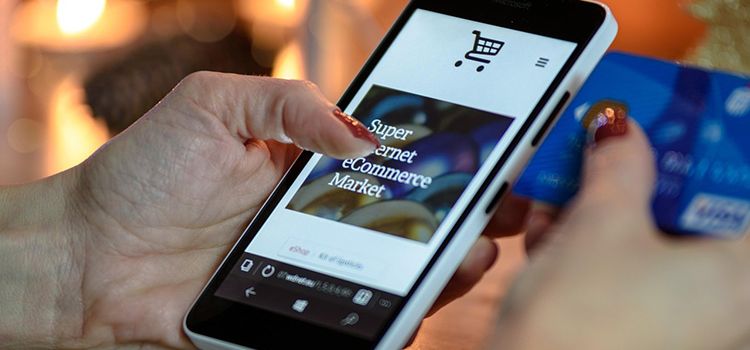 Weibliche Hand bedient Smartphone und bezahlt einen Einkauf