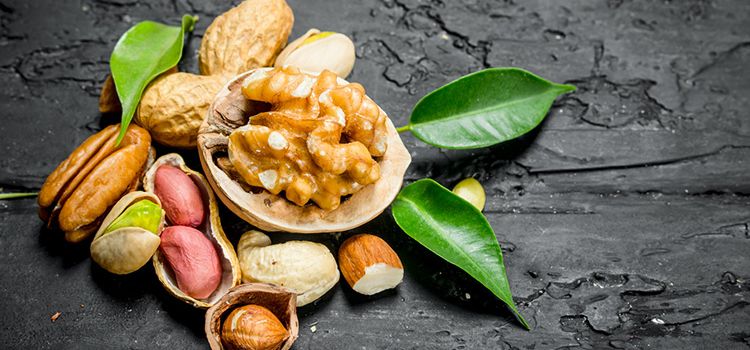 Geöffnete Nüsse auf schwarzem Schiefertisch