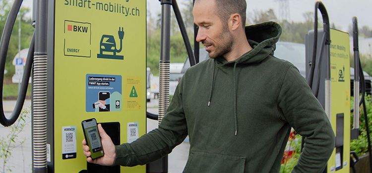 Junger Mann beim Auflagen seines E-Autos an einer Ladesäule