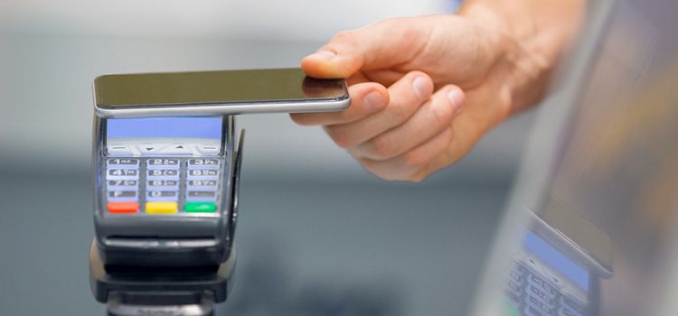 Hand mit Smartphone beim mobilen Bezahlen