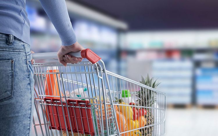 Eine Frau füllt im Supermarkt ihren Einkaufswagen
