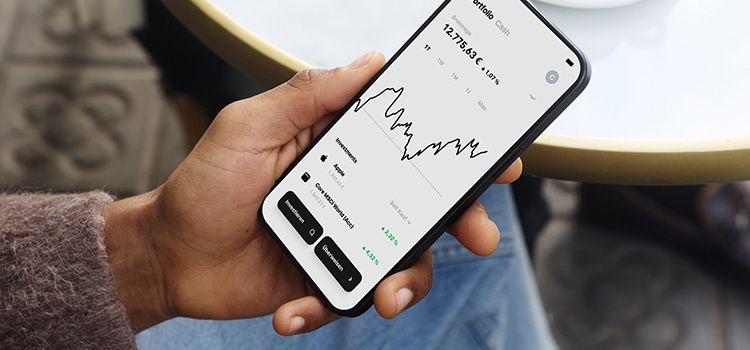 Eine Hand mit Smartphone zeigt die Benutzeroberfläche des Neo-Brokers Trade Republic