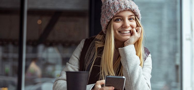 Junge Frau lachend an ihrem Smartphone