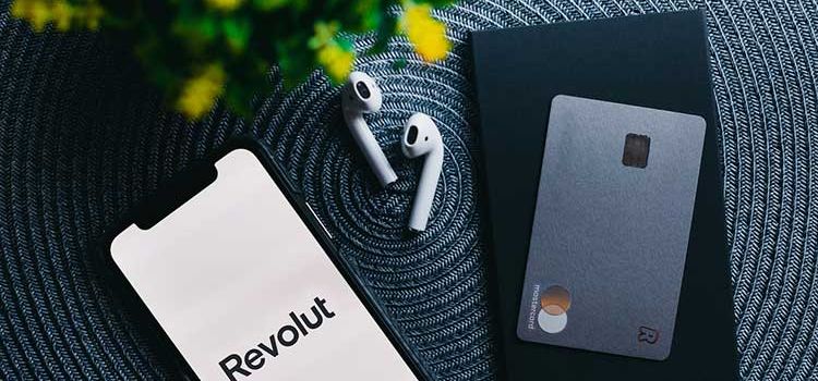 Smartphone mit Revolut-App und Debitkarte
