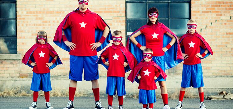Eine Familie, Eltern und Kinder verkleidet als Super Man