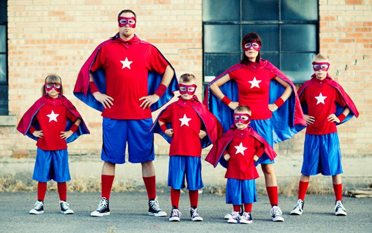 Eine Familie, Eltern und Kinder verkleidet als Super Man