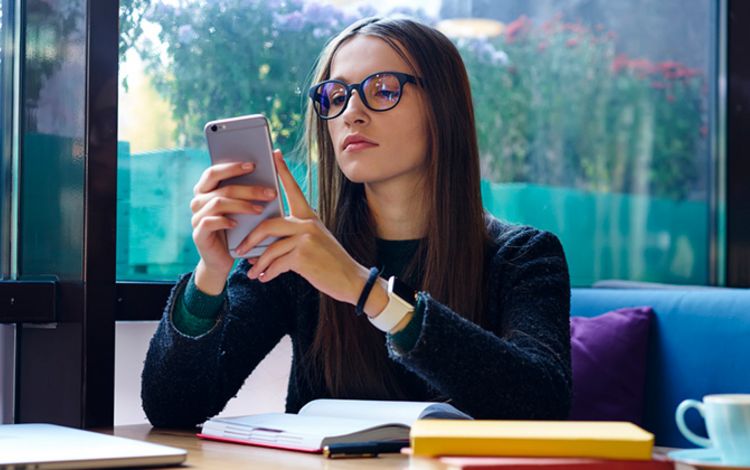 Junge Frau konzentriert am Smartphone