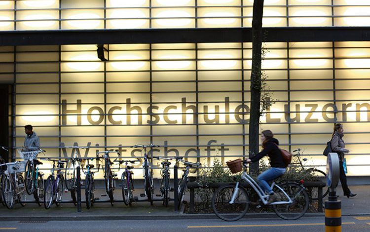 Das beleuchtete Gebäude und der Eingang der Hochschule Luzern