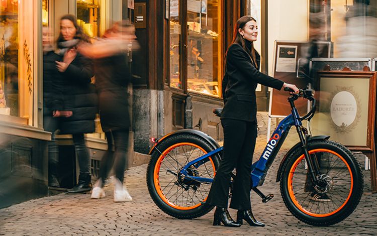 Junge Frau in der Stadt mit einem Citybike