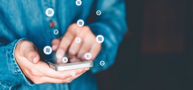 Mann mit Smarphone der Libra-Transaktionen ausführt