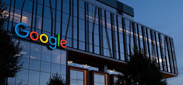Gebäude in der Dämmerung mit beleuchtetem Logo von Google