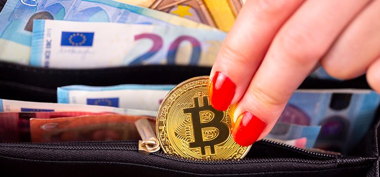 Eine Frau nimmt eine Bitcoin-Münze aus der Brieftasche