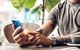 Junger Mann bedient sein Smartphone für Bankgeschäfte