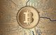 Bitcoin als Münze auf eine Platine