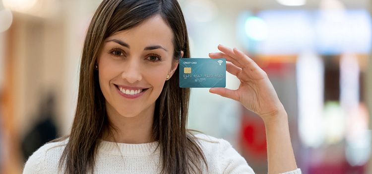 Junge Frau mit Kreditkarte in der Hand