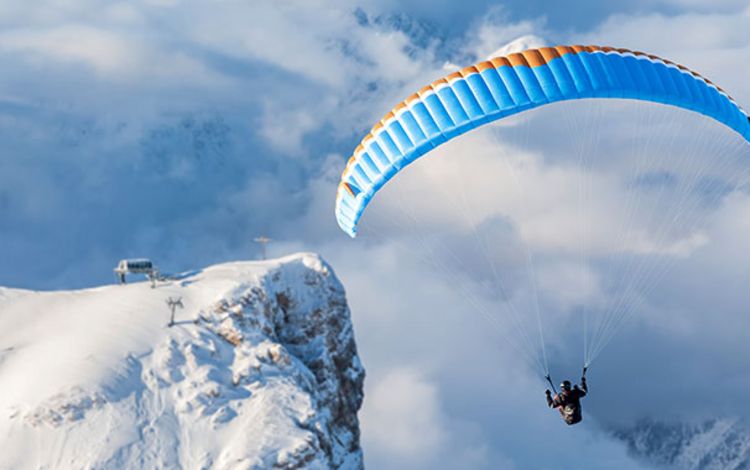 Gleitschirmpilot in den Alpen im Aufwind