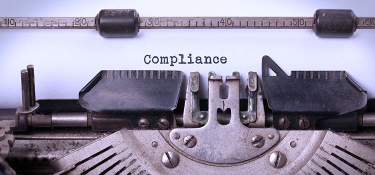 Alte Schreibmaschine mit Schriftzug Compliance auf eingespanntem Papier