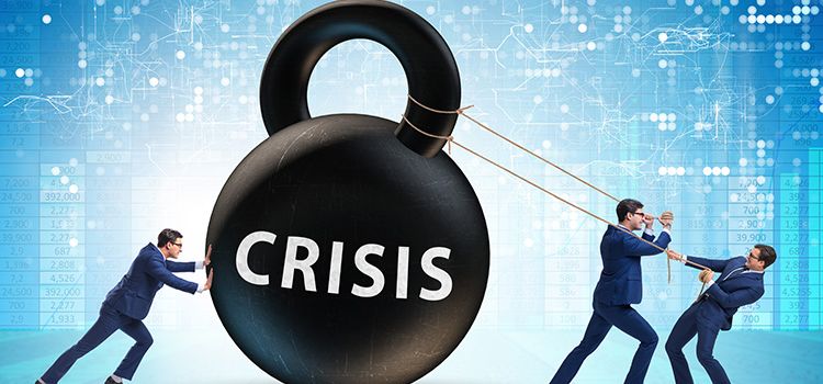 Manager in Anzügen zerren an einem Riesengewicht mit der Aufschrift Crisis