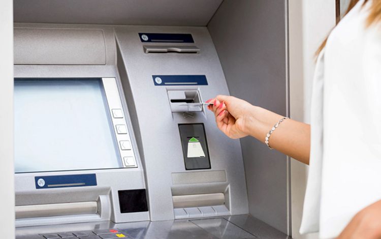 Geldautomat mit Frau beim Geldbezug