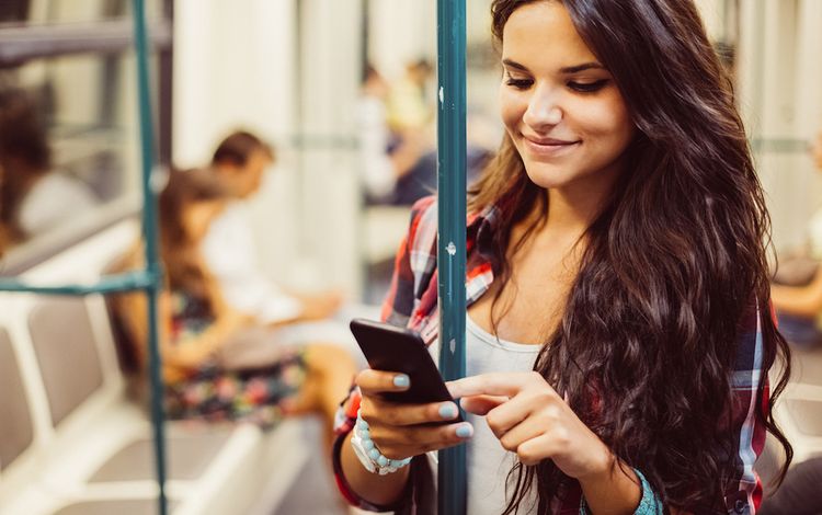 Mädchen in der Strassenbahn mit Smartphone