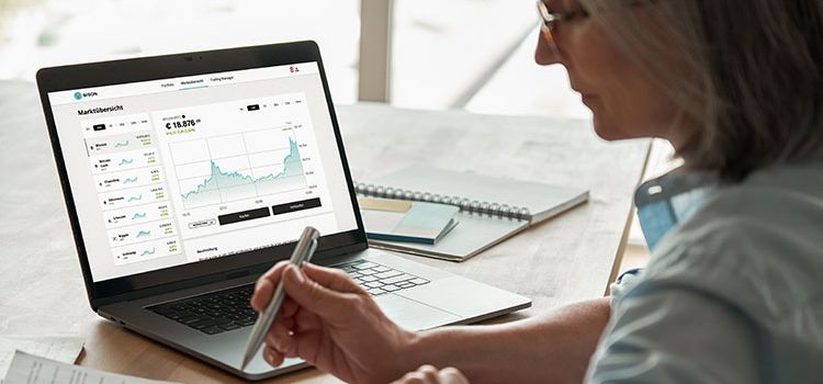 Frau am Laptop mit dem Handel von Kryptowährungen beschäftigt