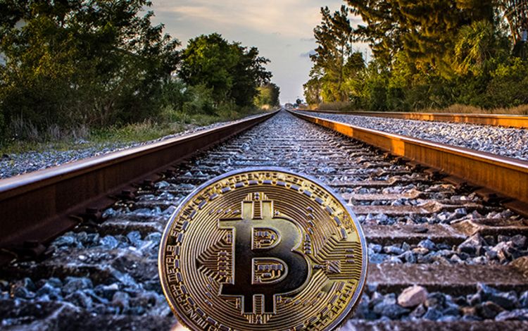 Eine Bitcoin-Münze liegt auf Schienen