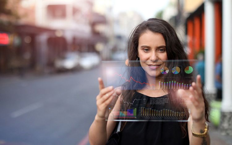 Eine junge Frau schaut auf einem Tablet auf der Strasse ihre digitalen Assets an
