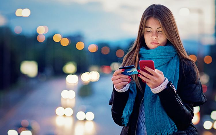 Junge Frau macht eine Zahlung am Smartphone