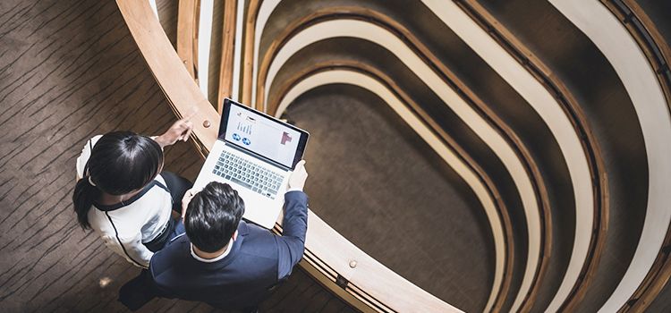 Frau und Mann schauen zusammen in einen Laptop