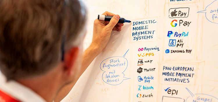 Mann schreibt und illustriert eine Tafel am Swiss Payment Forum
