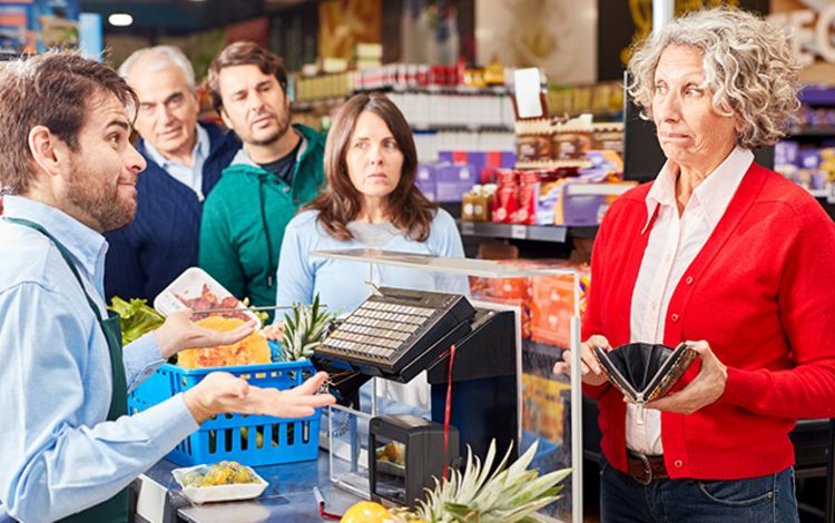 Frau an der Supermarktkasse beim Bezahlen