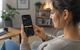 Junge Frau beim Aktienhandel am Smartphone