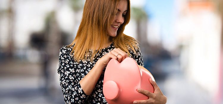 Junge Frau mit grossem Sparschwein in der Hand