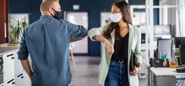 Zwei Mitarbeiter im Büro mit Schutzmasken