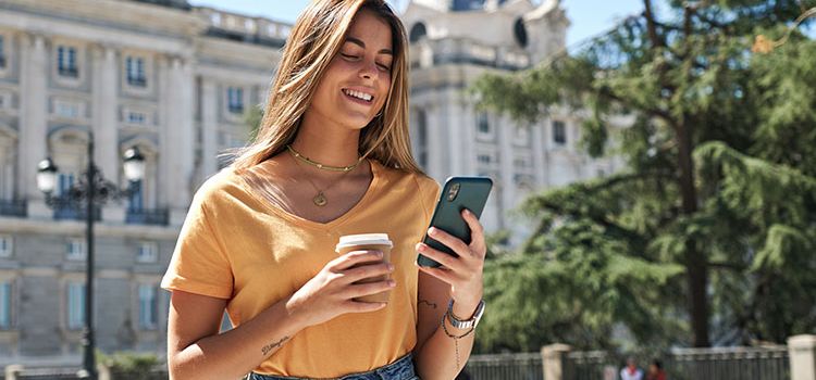 Junge Frau im Urlaub, die ihr Handy checkt