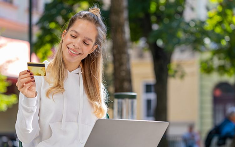 Junge Frau mit Kreditkarte und Laptop