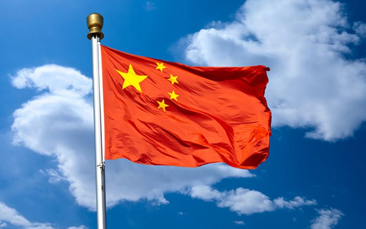 Die Flagge von China im Wind gegen blauen Himmel