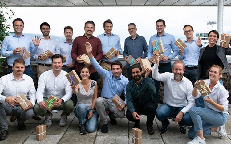 Das Team des FinTechs Loanboox, alle Mitglieder mit einem Geschenkpaket in der Hand.