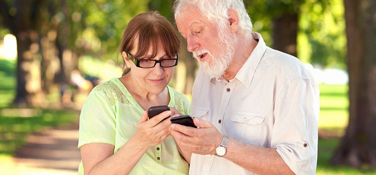 Seniorenpaar schaut auf seine Smartphones