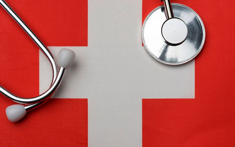Schweizer Flagge mit Stethoskop als Symbol für das Schweizer Gesundheitswesen