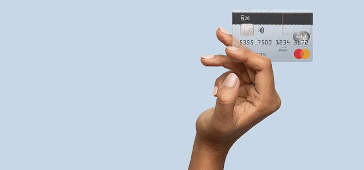 Eine weibliche Hand präsentiert eine Debitkarte der Neo-Bank N26