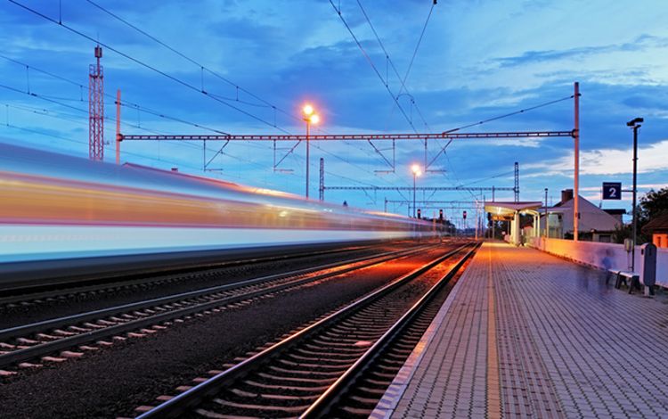 Mehrere Gleise mit Zug in schneller Fahrt