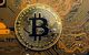 Goldene Bitcoin-Münze liegt auf einem Mainboard